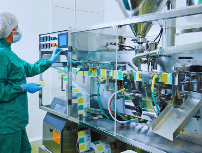 Operator monitoring an automated packaging line in a pharmaceutical manufacturing facility