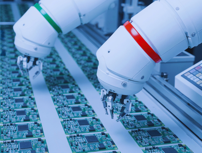 Robotic arms placing components on printed circuit boards on a production line